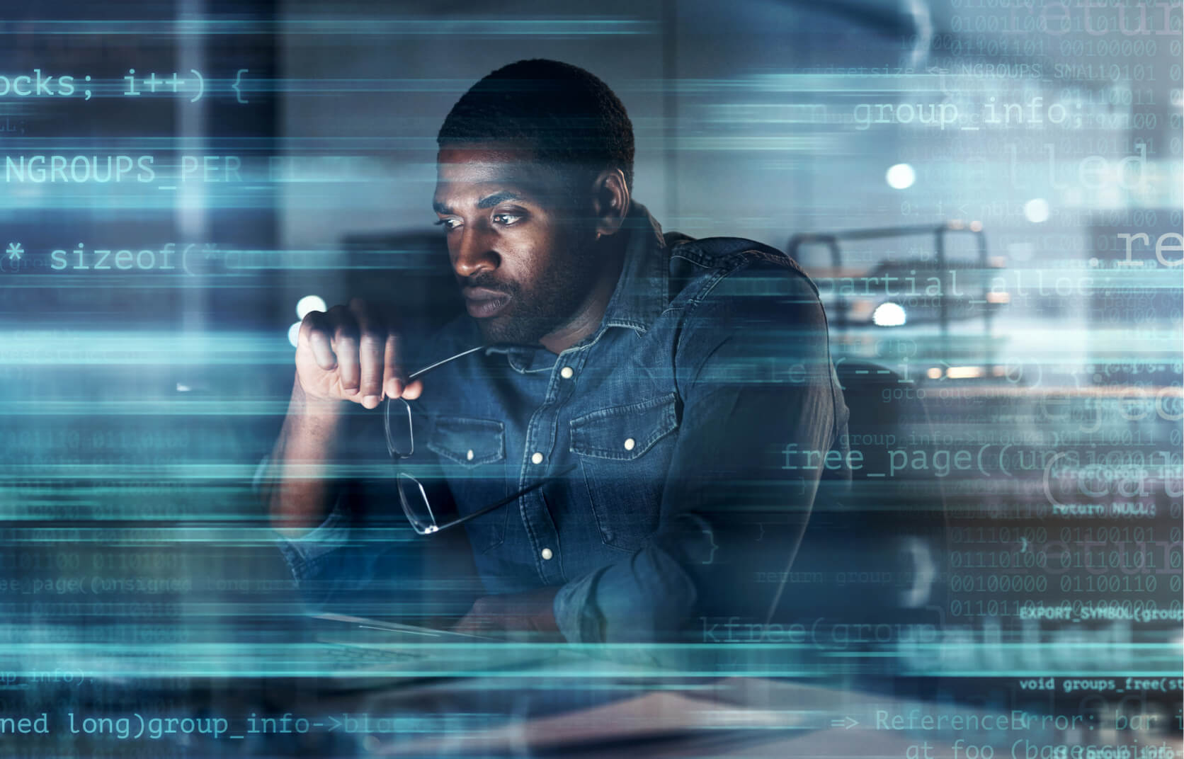 A man sitting at a computer deep in thought with an overlay of code and other cybersecurity concepts