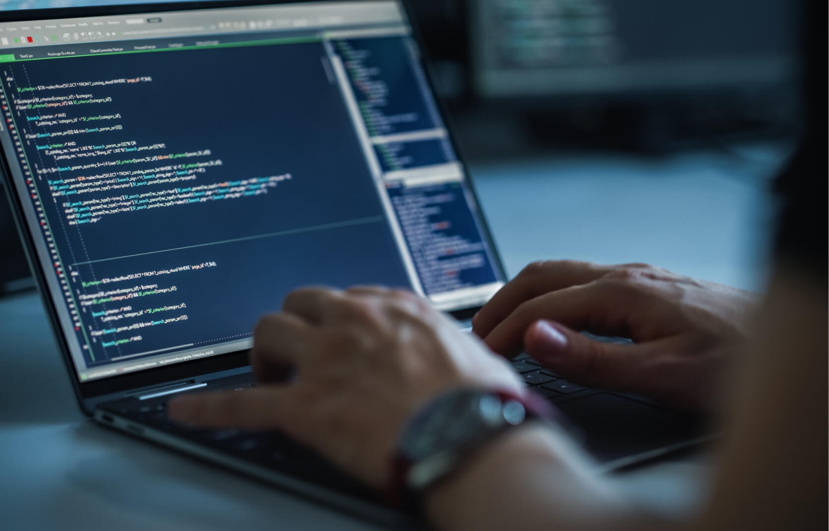 Close up of hands typing on a keyboard as someone writes code