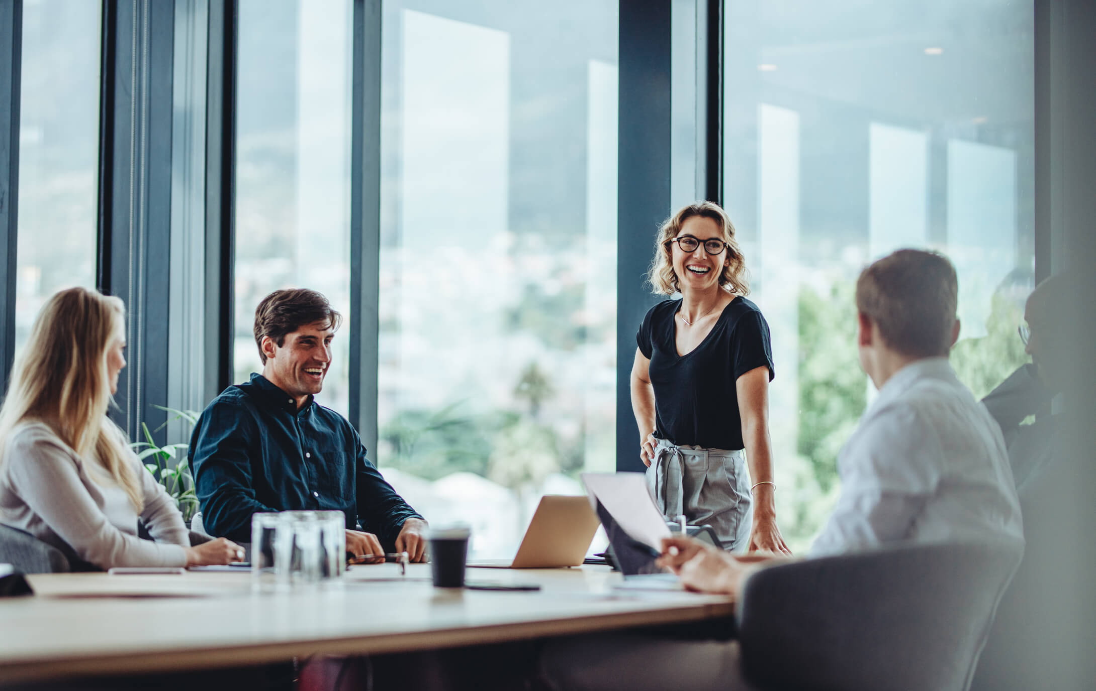 A team of cybersecurity professionals smiling and talking during a meeting