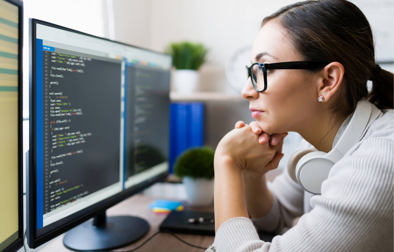 A female cybersecurity professional stares at a computer screen with lines of code