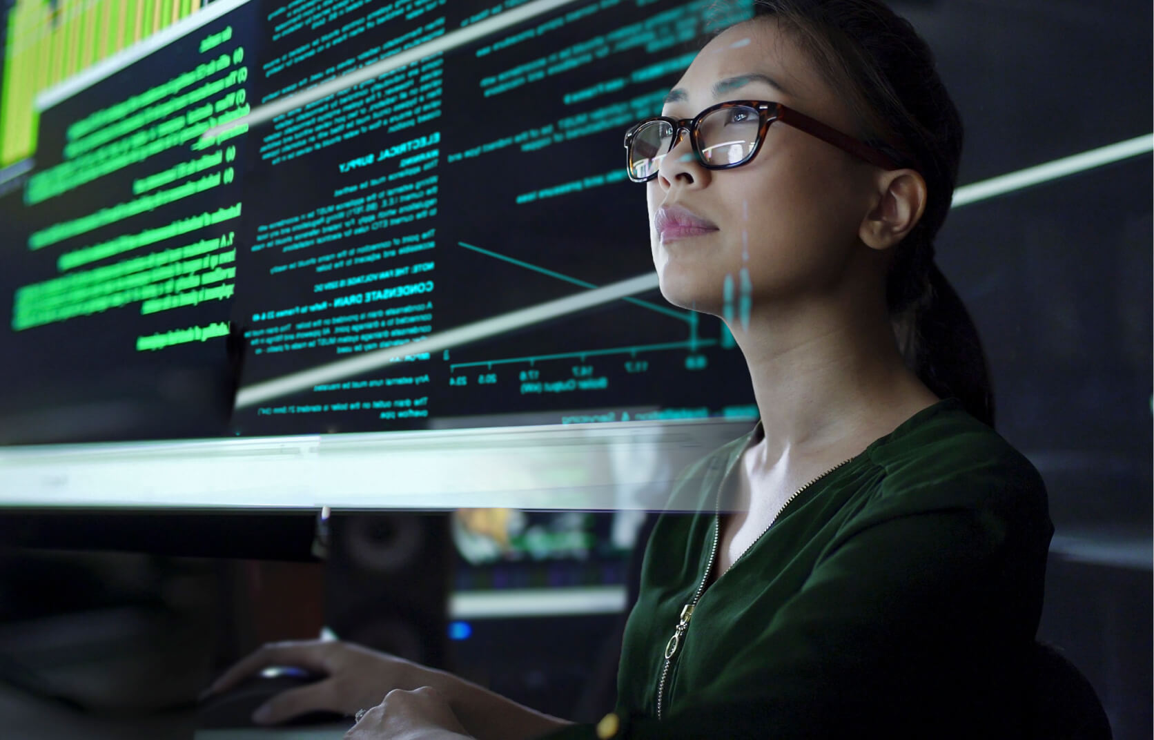 A young woman with glasses reviews code and cybersecurity risk data on a virtual screen display