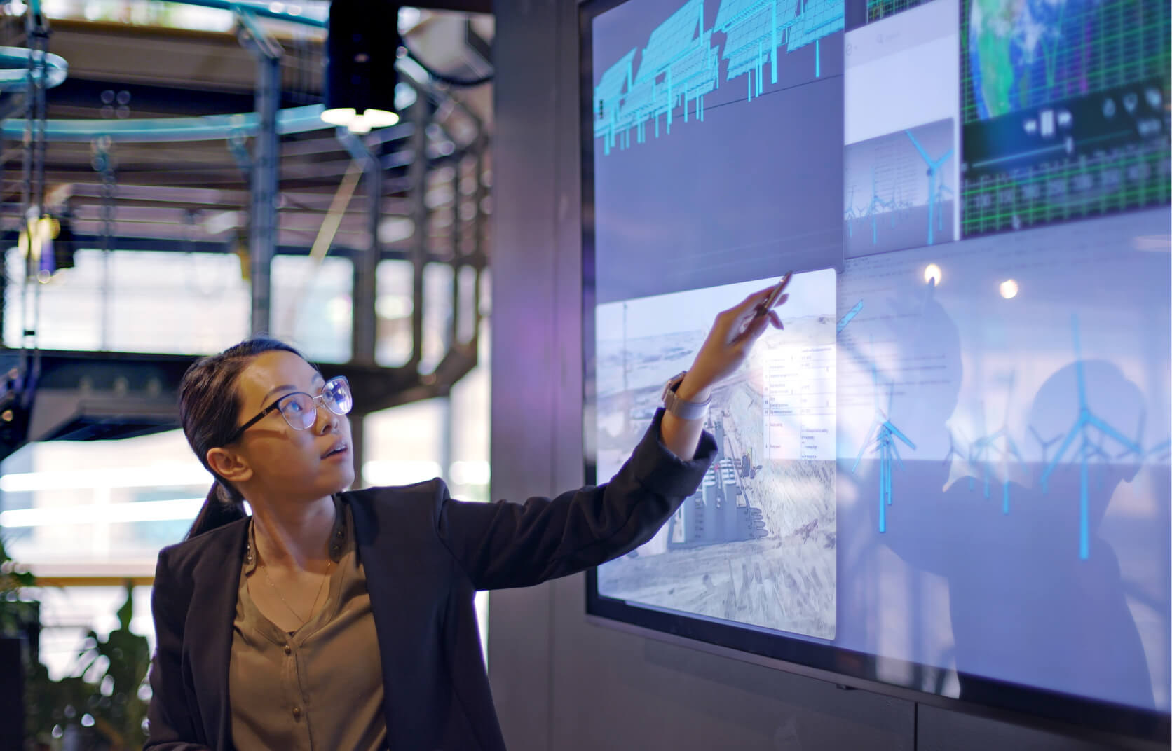 A young female cybersecurity professional pointing to a board of data during a security awareness training session