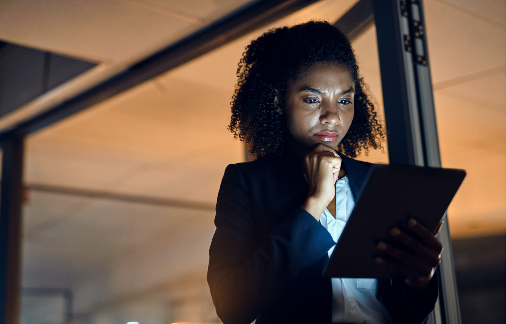 A young woman in a suit reviews application security and vulnerabilities on a handheld tablet